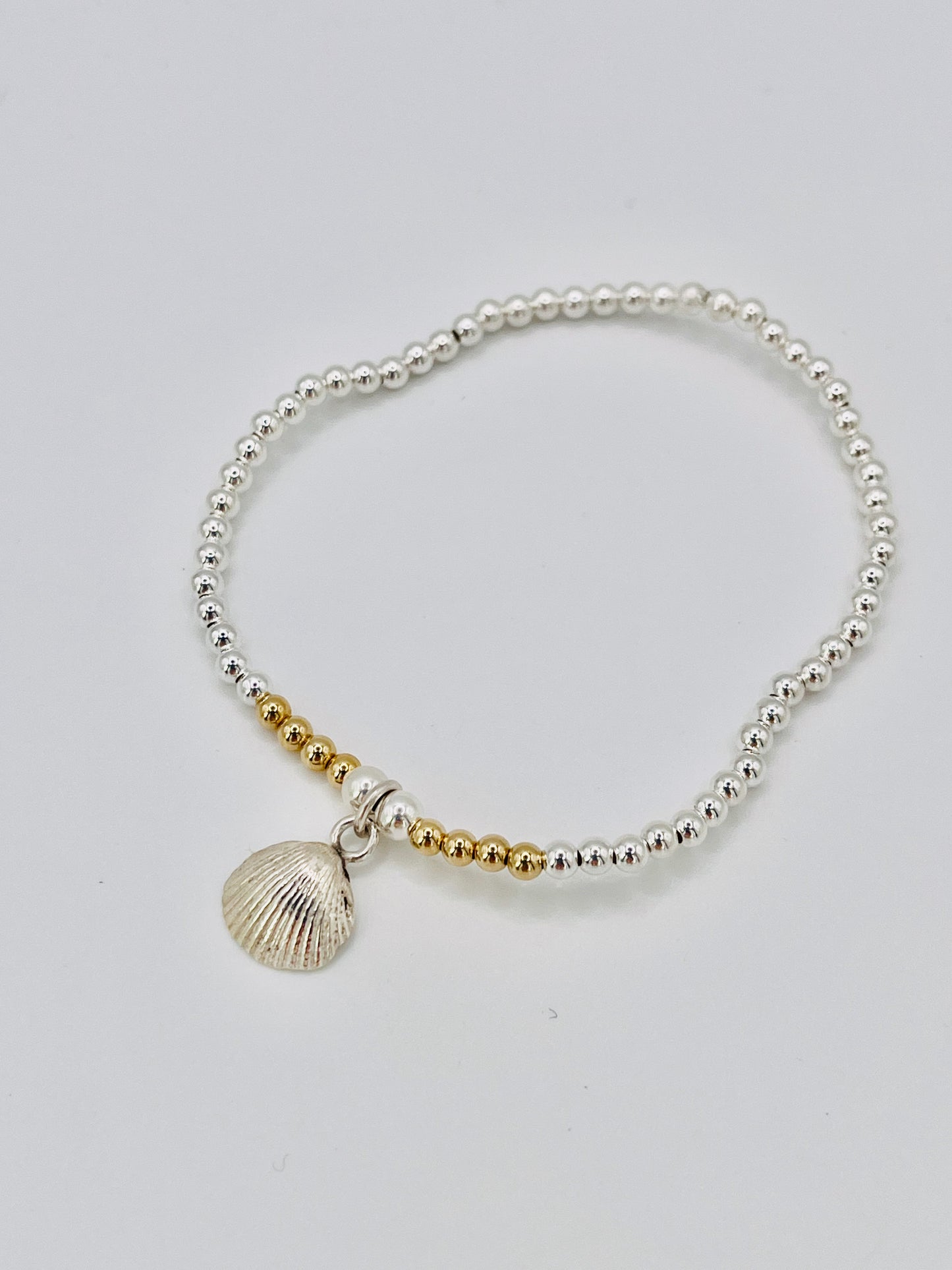 Silver and gold beaded bracelet with scallop shell.