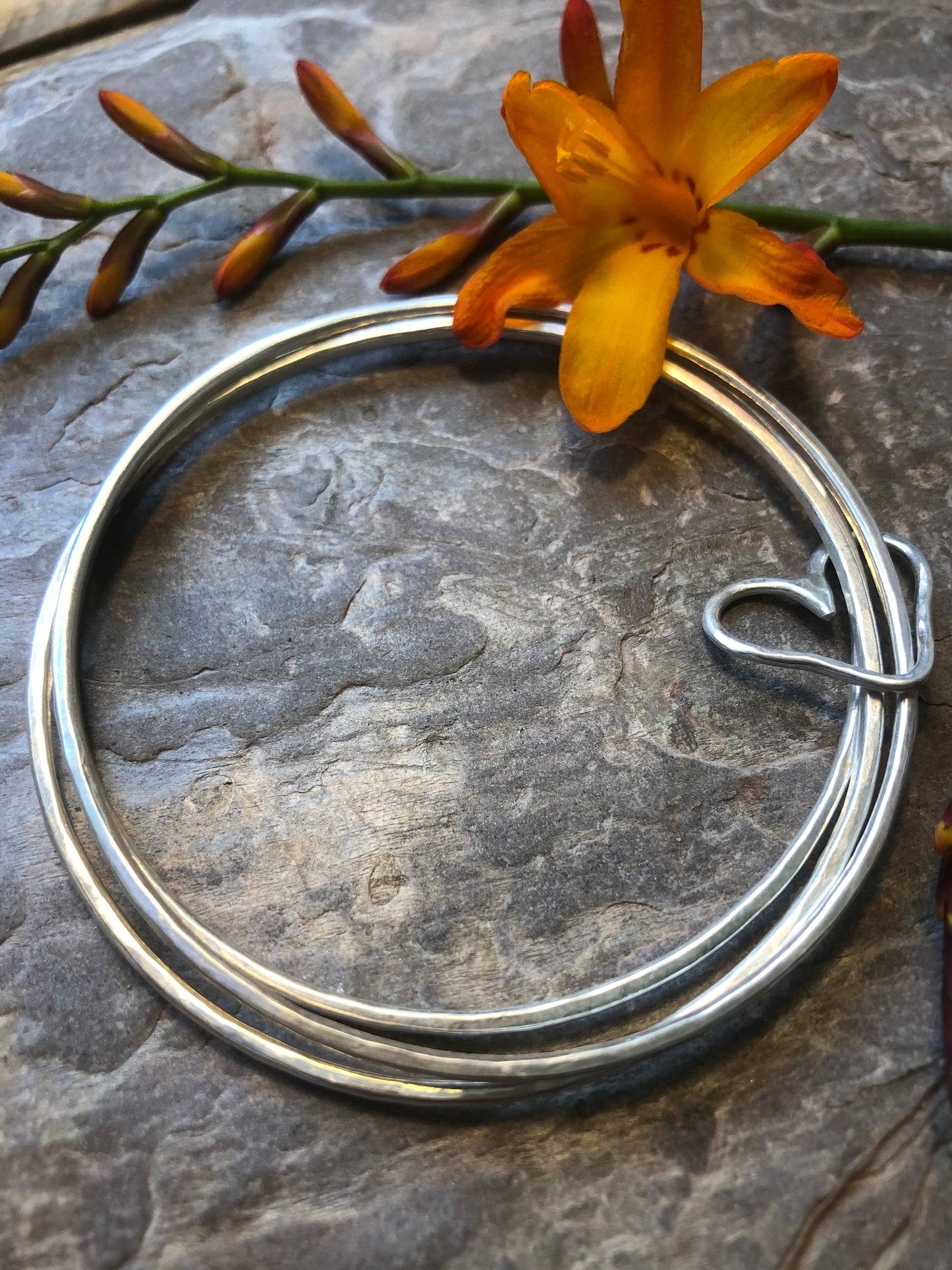 Triple stacking bangle with joining heart.