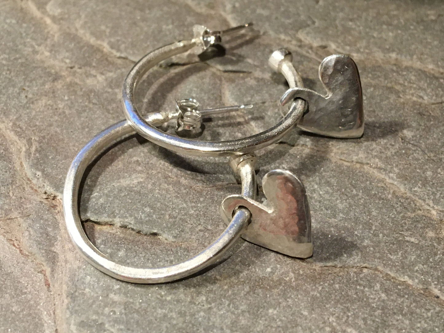 Silver hoops with hanging hearts.
