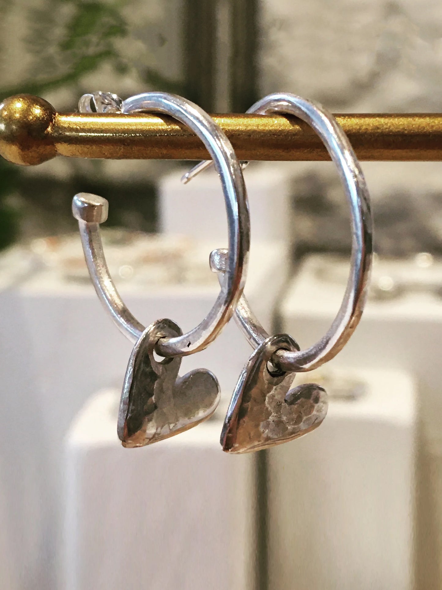 Silver hoops with hanging hearts.