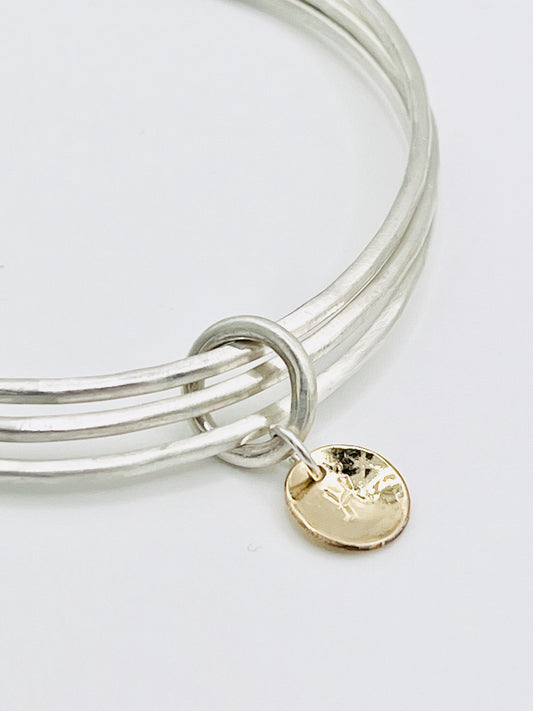 Triple stacking bangle with gold disc.