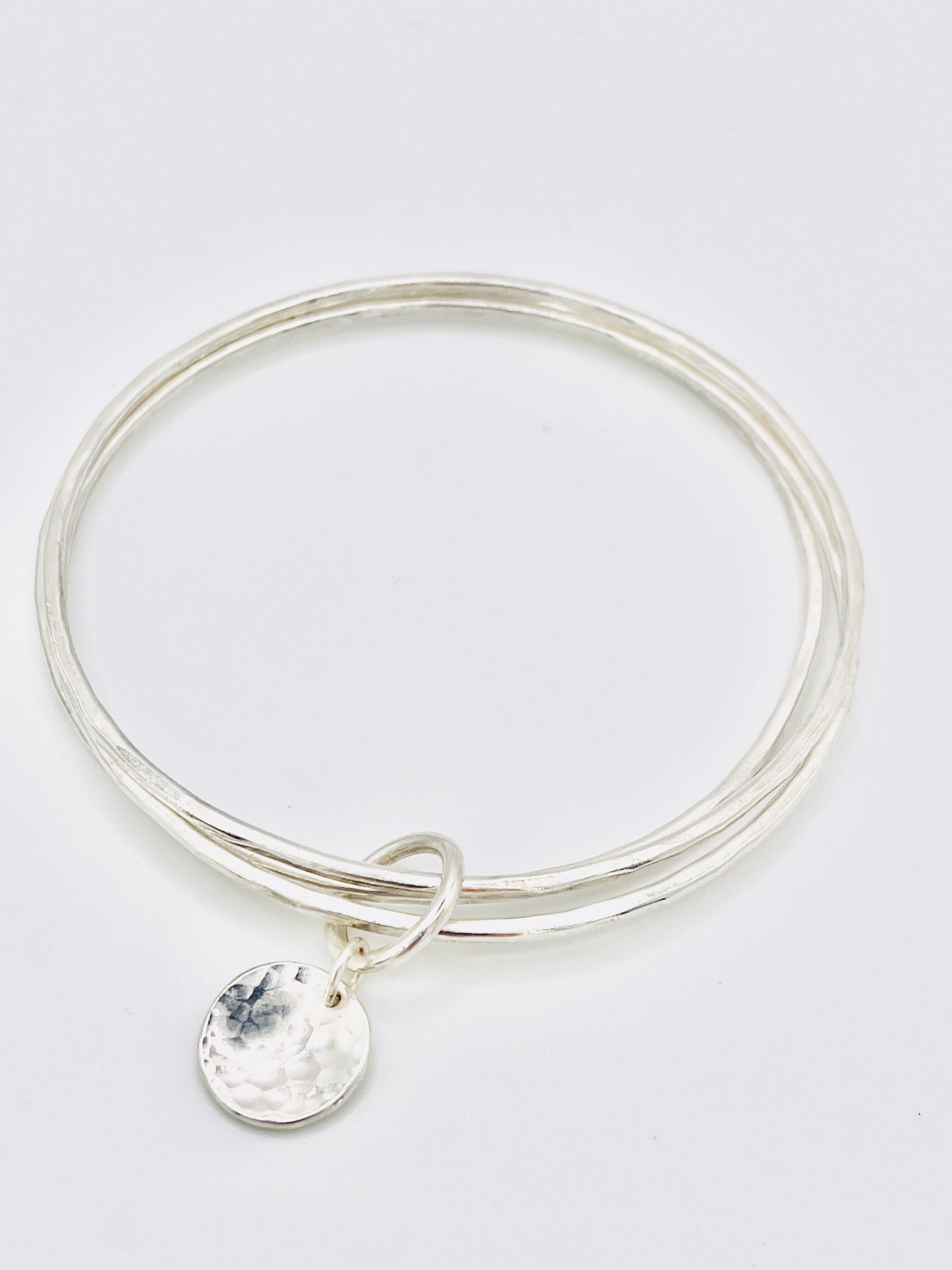 Triple silver bangle stack.