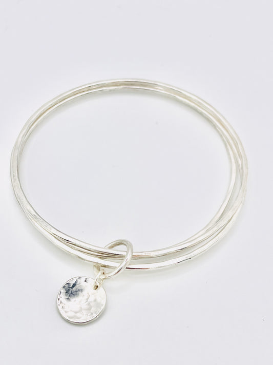 Triple silver bangle stack.
