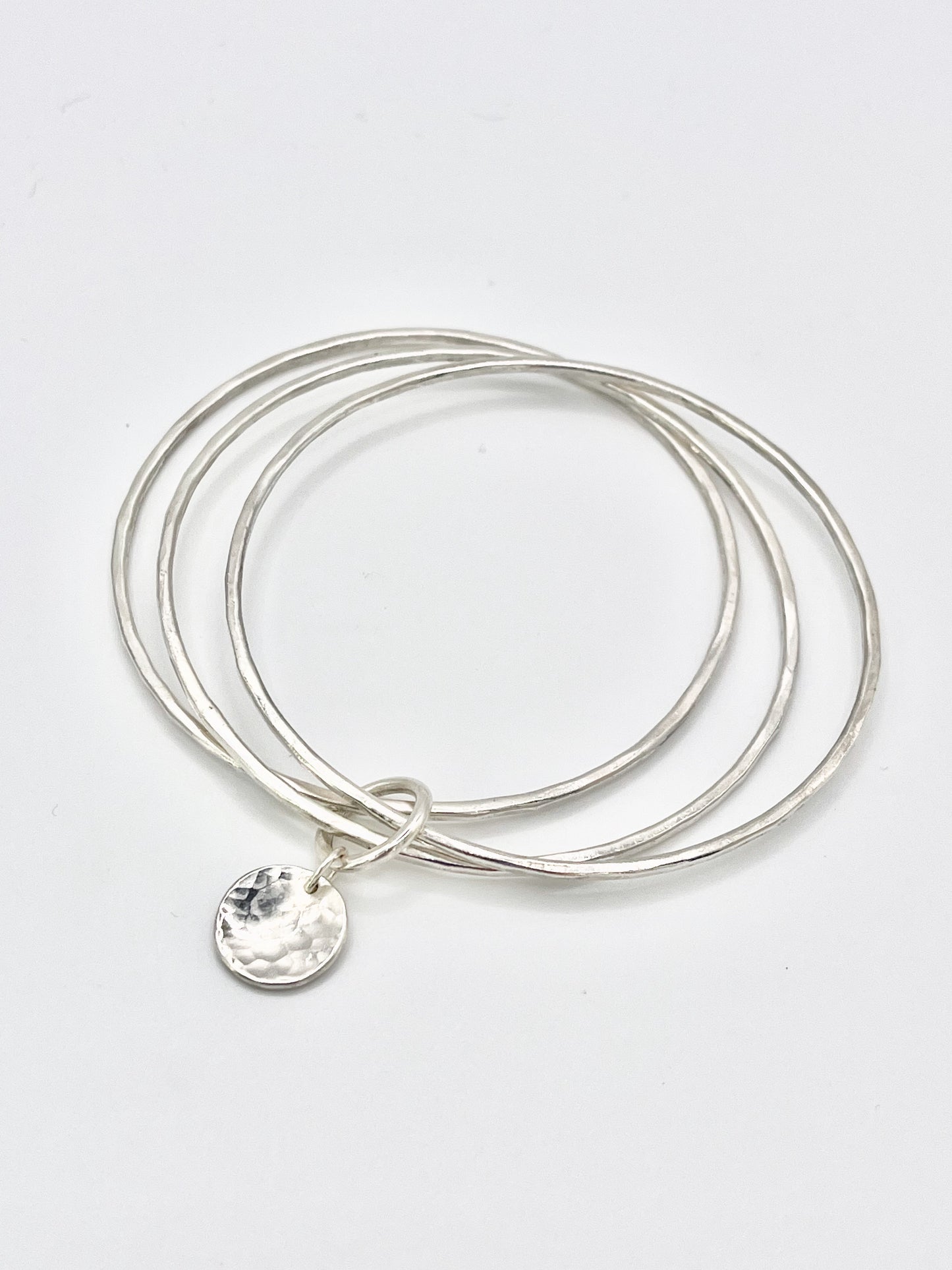 Triple silver bangle stack.