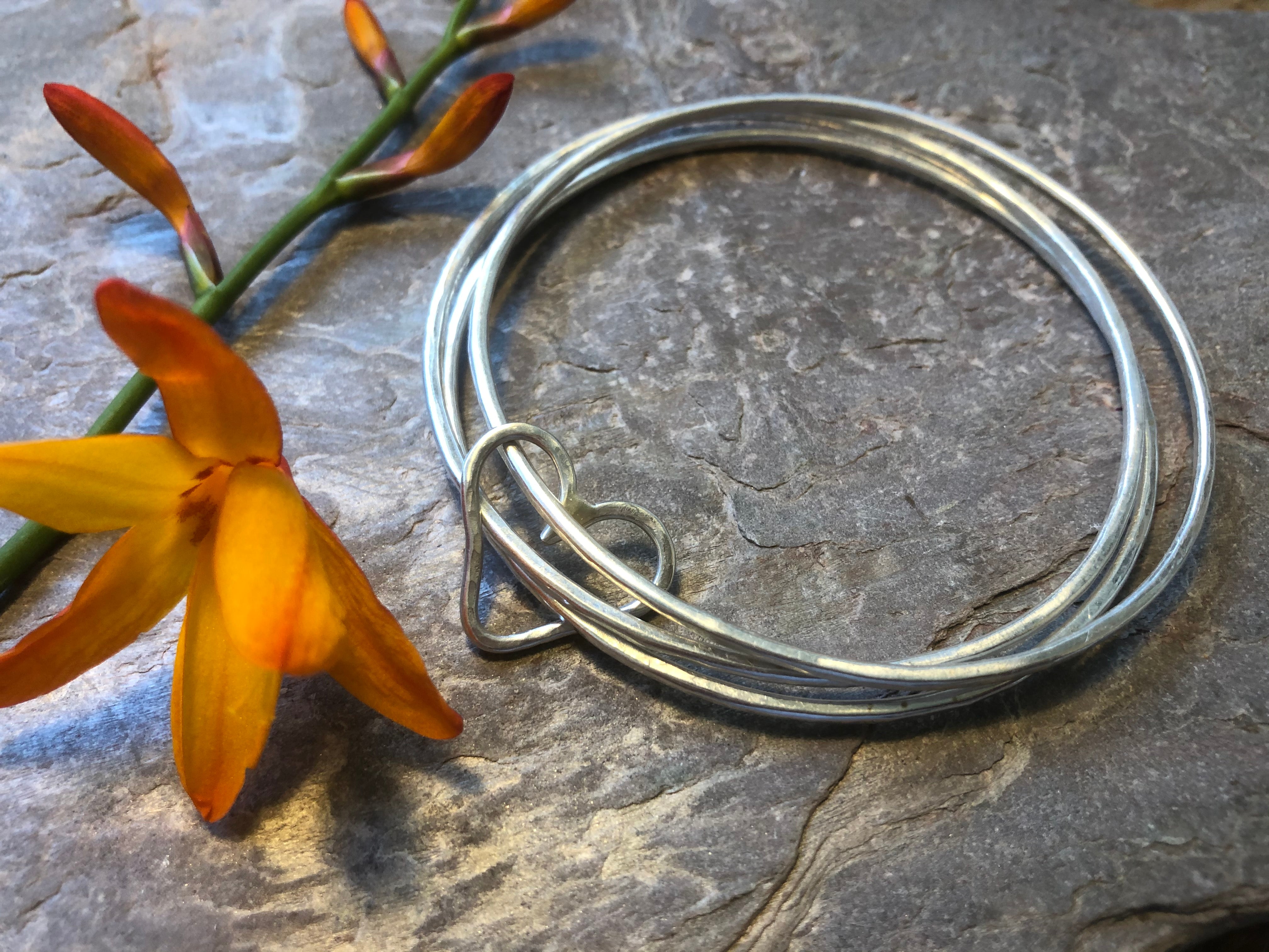 Triple stacking bangle with joining heart.