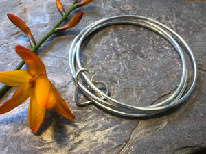 Triple stacking bangle with joining heart.
