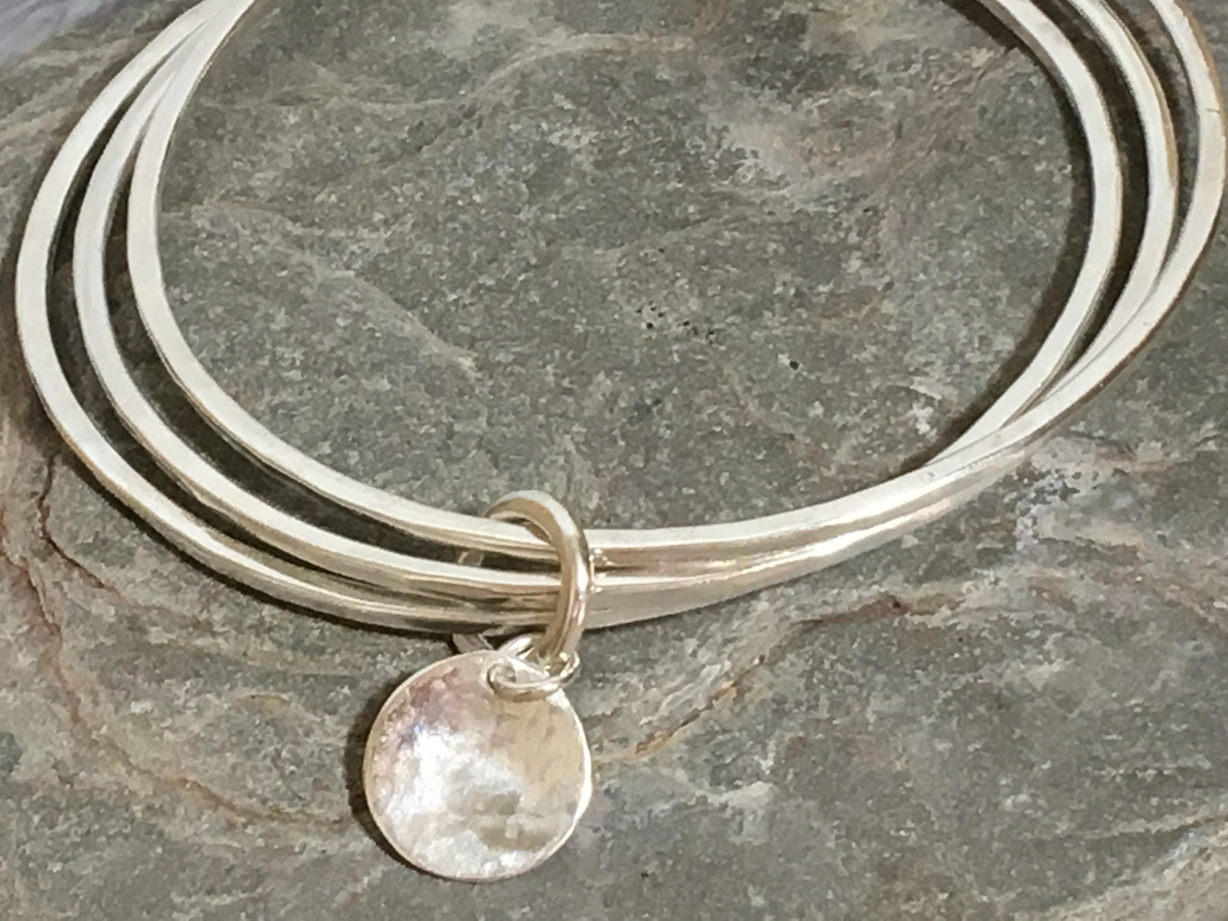 A trio of textured silver bangles.