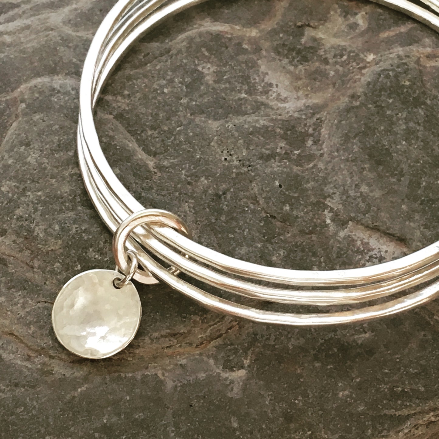Triple silver bangle stack.