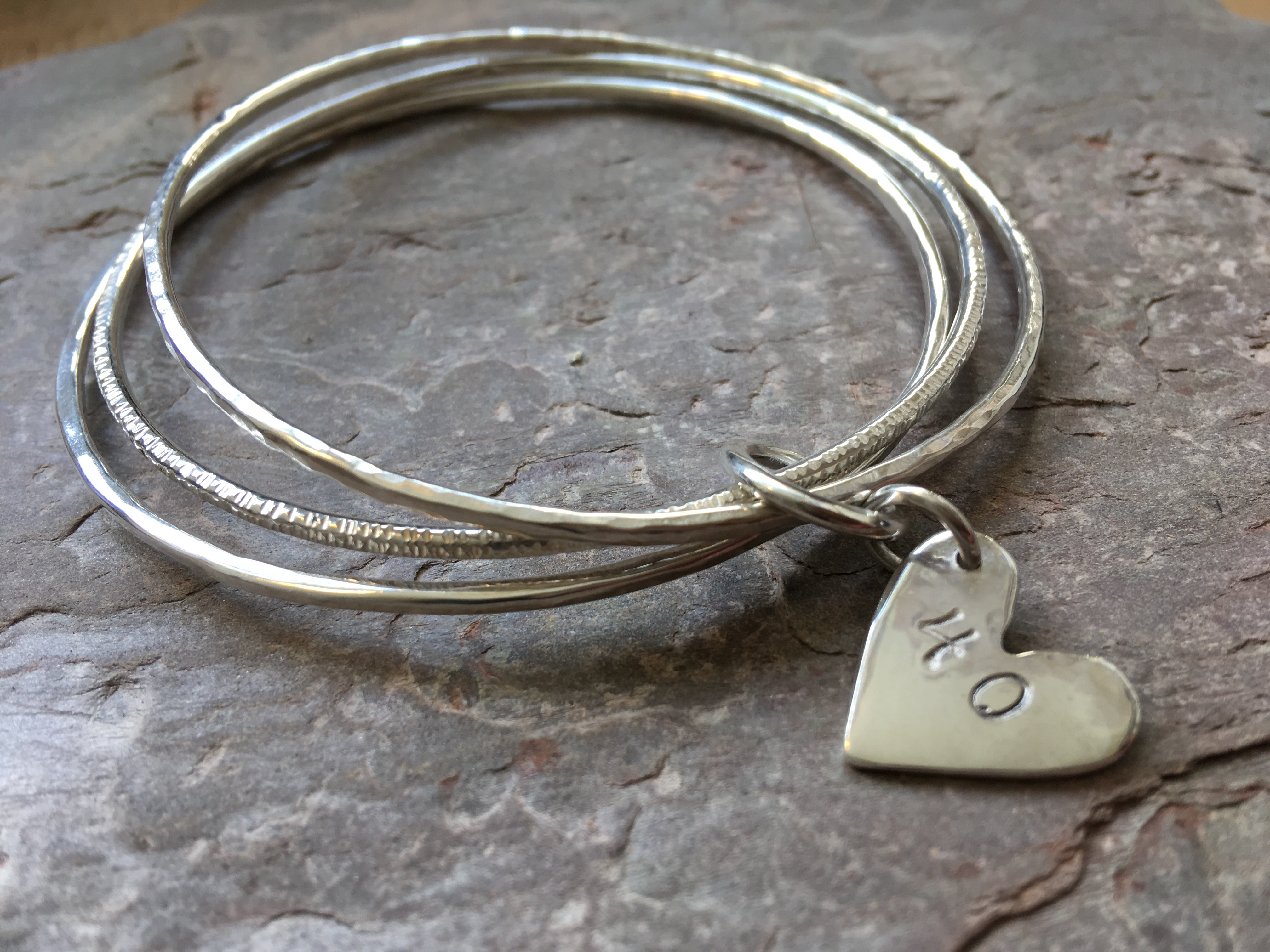 Silver triple linked bangle with personalised heart charm.