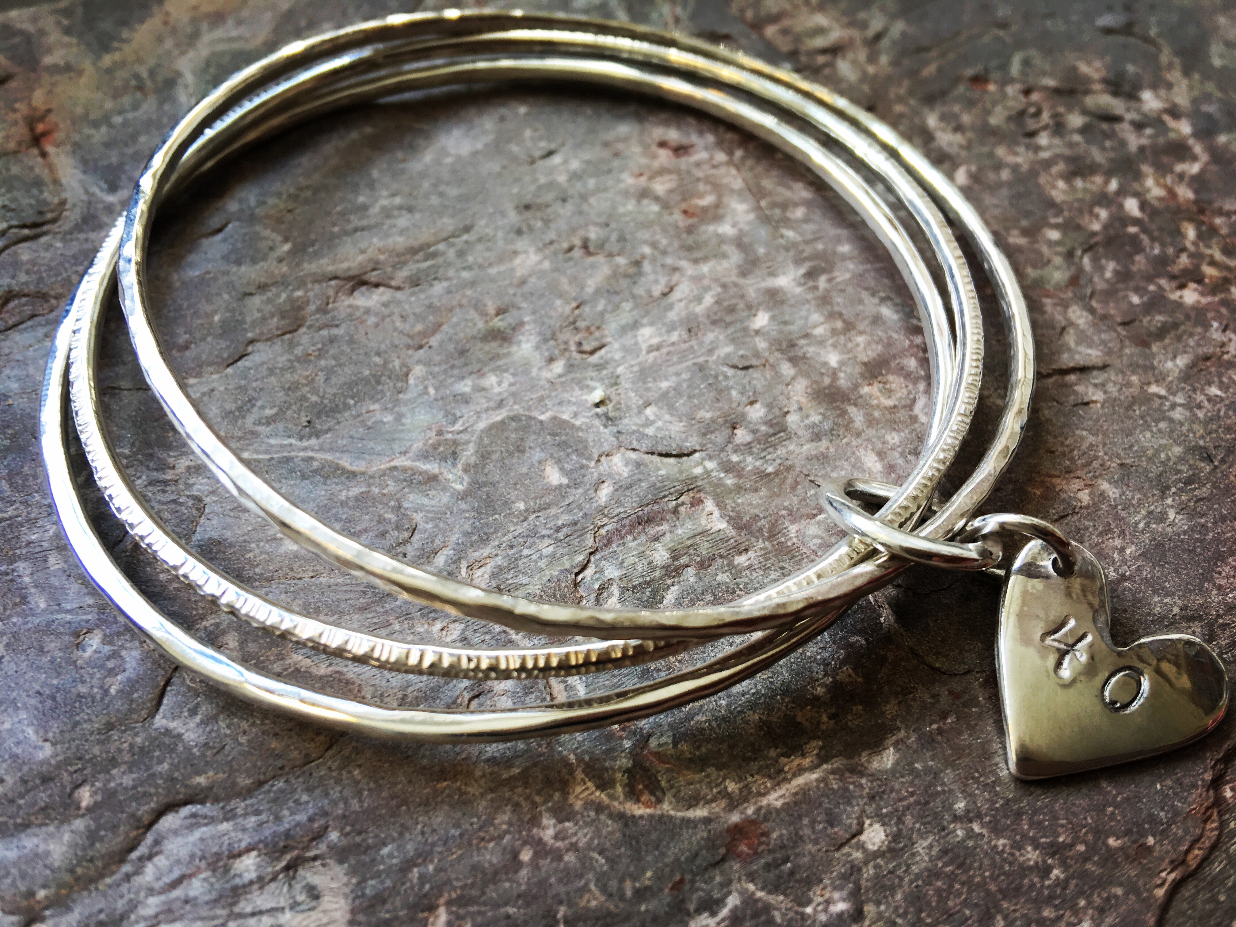 Silver triple linked bangle with personalised heart charm.