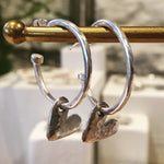 Silver hoops with hanging hearts.