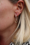 Silver hoop earings with gold disc.